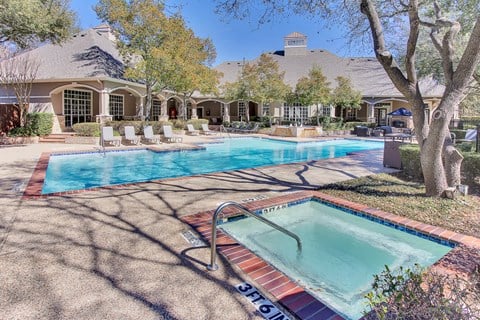 Stunning, tree-lined swimming pool and hot tub with tanning deck and lounge seating